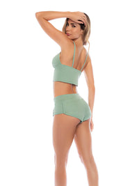 Woman wearing a green bikini set on a white background