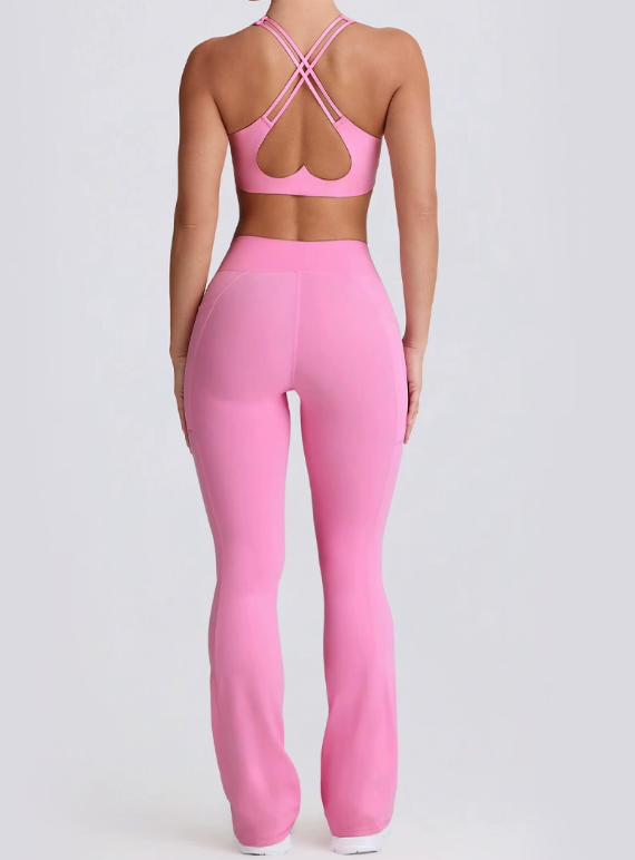 Person wearing a pink sports bra and leggings set on a light gray background