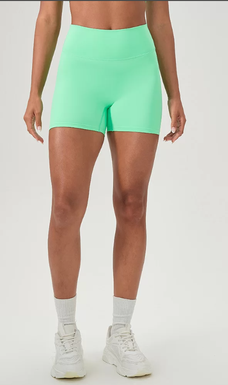 Person wearing bright green shorts on a white background