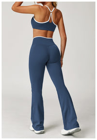 Person wearing blue athletic pants and sports bra on a plain background