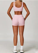 Person wearing a pink sports bra and shorts set