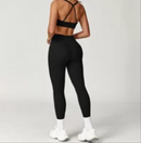 Person wearing a black sports bra and leggings set on a white background