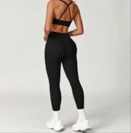 Person wearing a black sports bra and leggings set on a white background