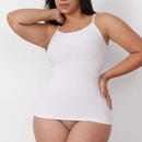 Woman wearing a white camisole against a plain background